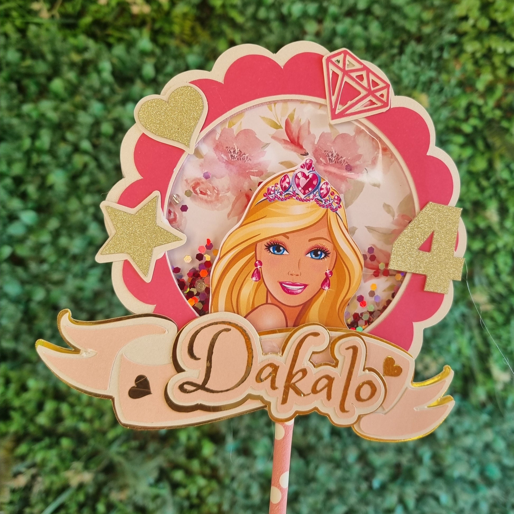 A custom cake topper featuring an illustration of a Barbie character with a number '4' on it, designed in pink and gold colors with glitter accents, intended for a birthday celebration.