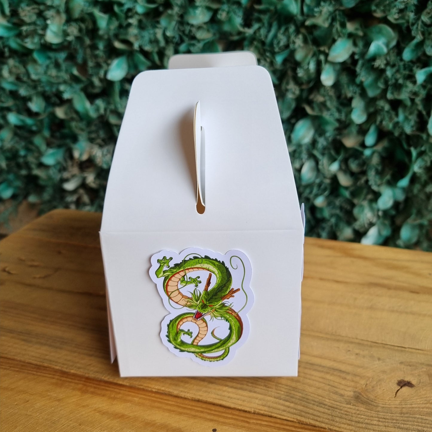 Open book with a sticker of pretzels on a wooden surface with greenery in the background