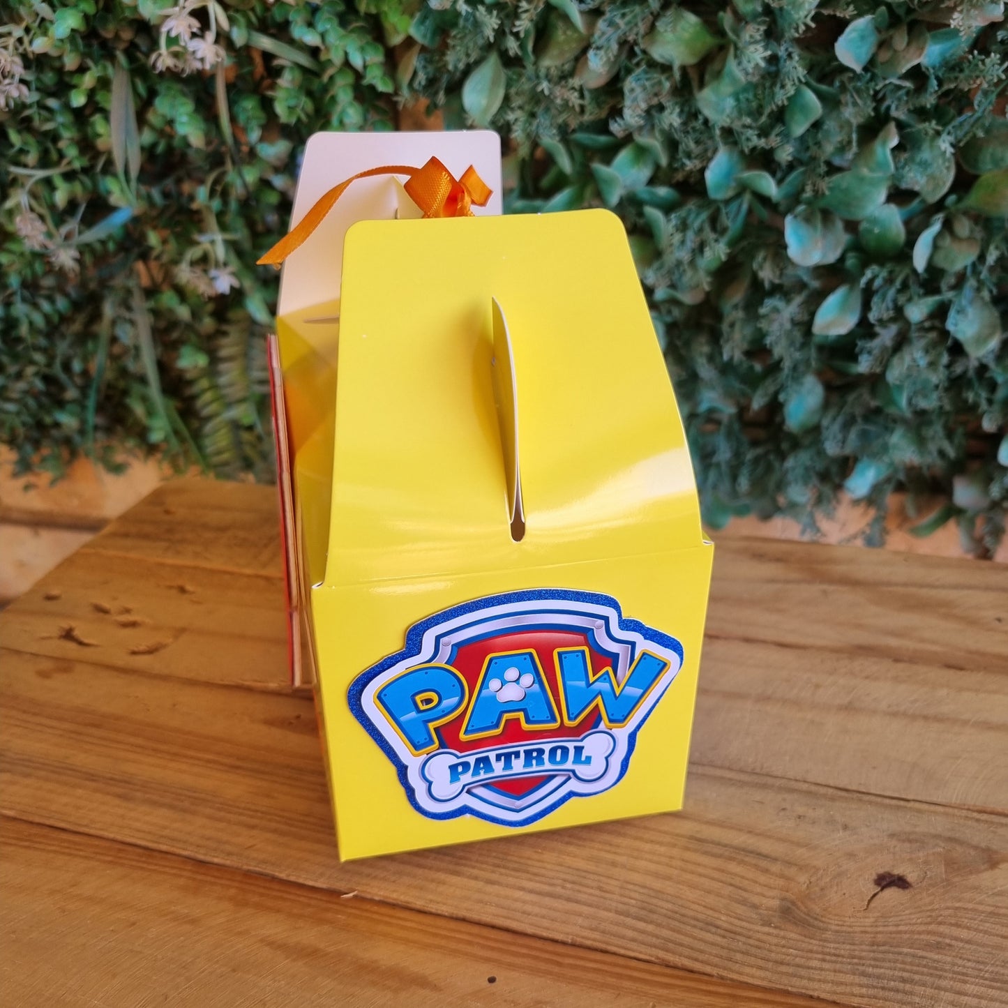 Yellow box with a logo on a wooden surface