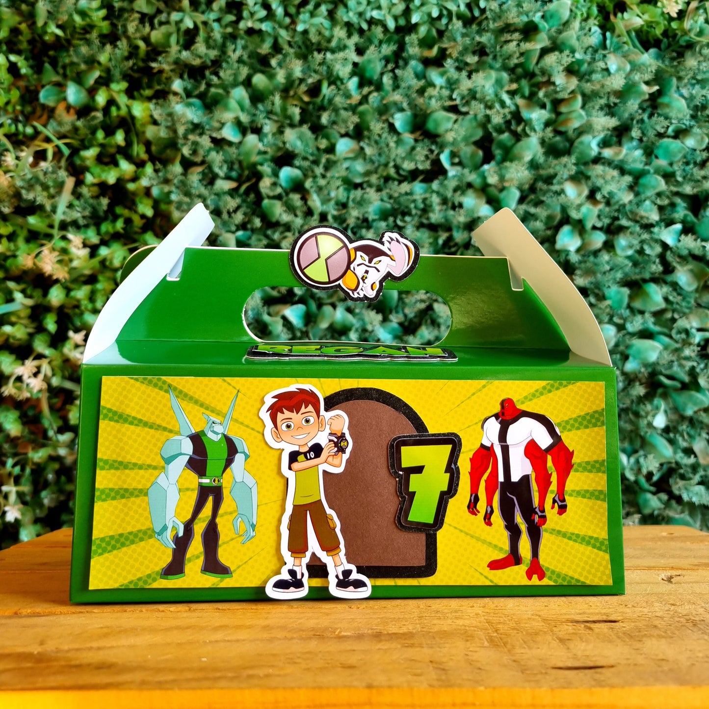 Colorful mailbox with cartoon designs on a wooden post against a green bush background