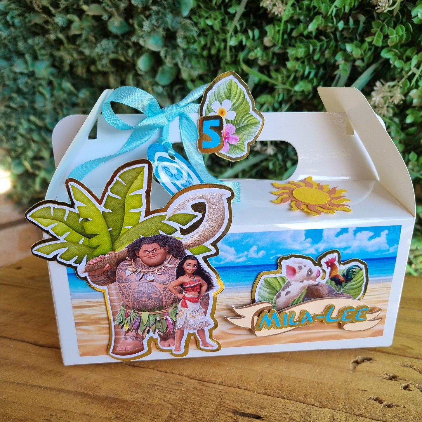 Decorative box with cartoon characters and scenic design on a wooden surface