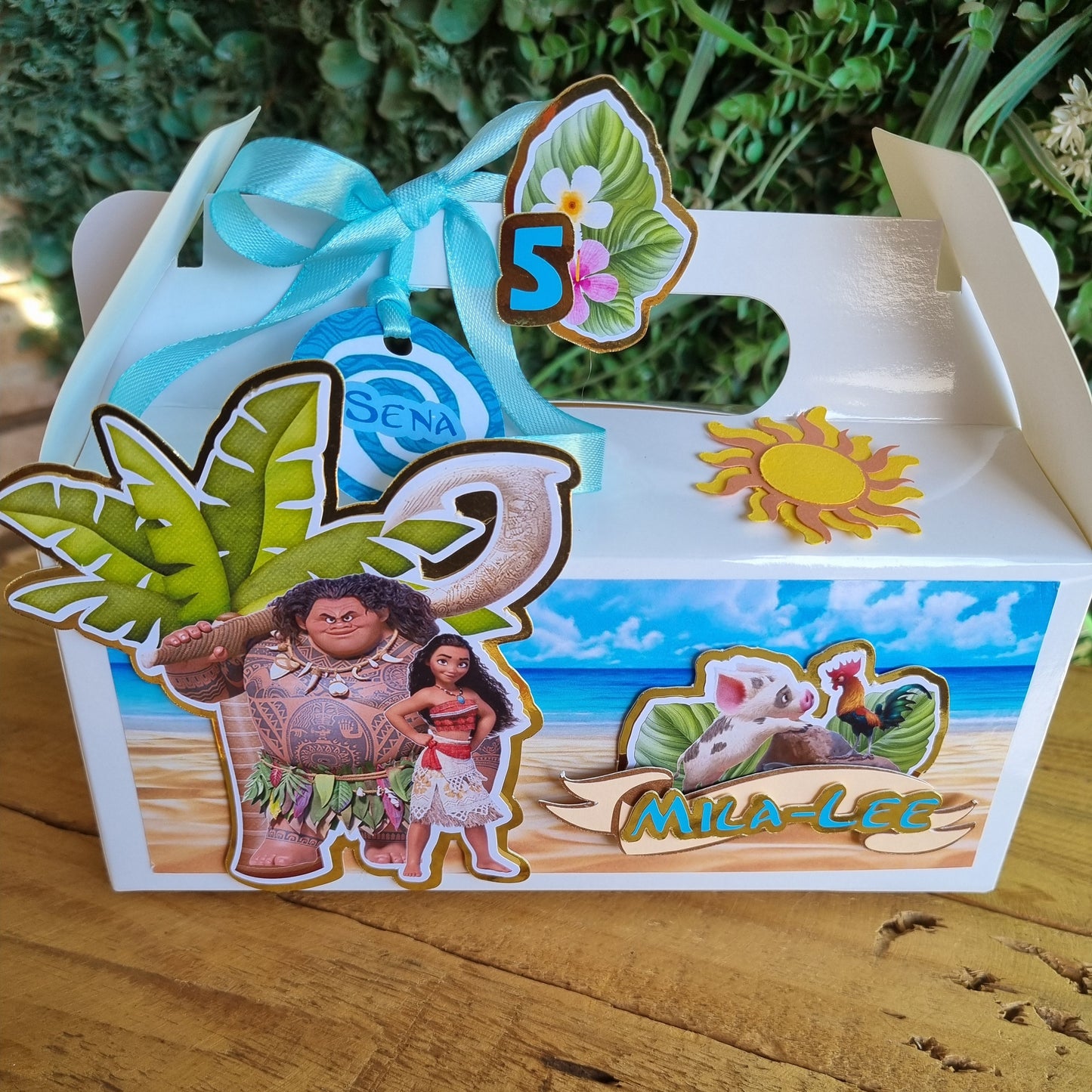 Decorative mailbox with colorful stickers featuring people and nature on a wooden surface.