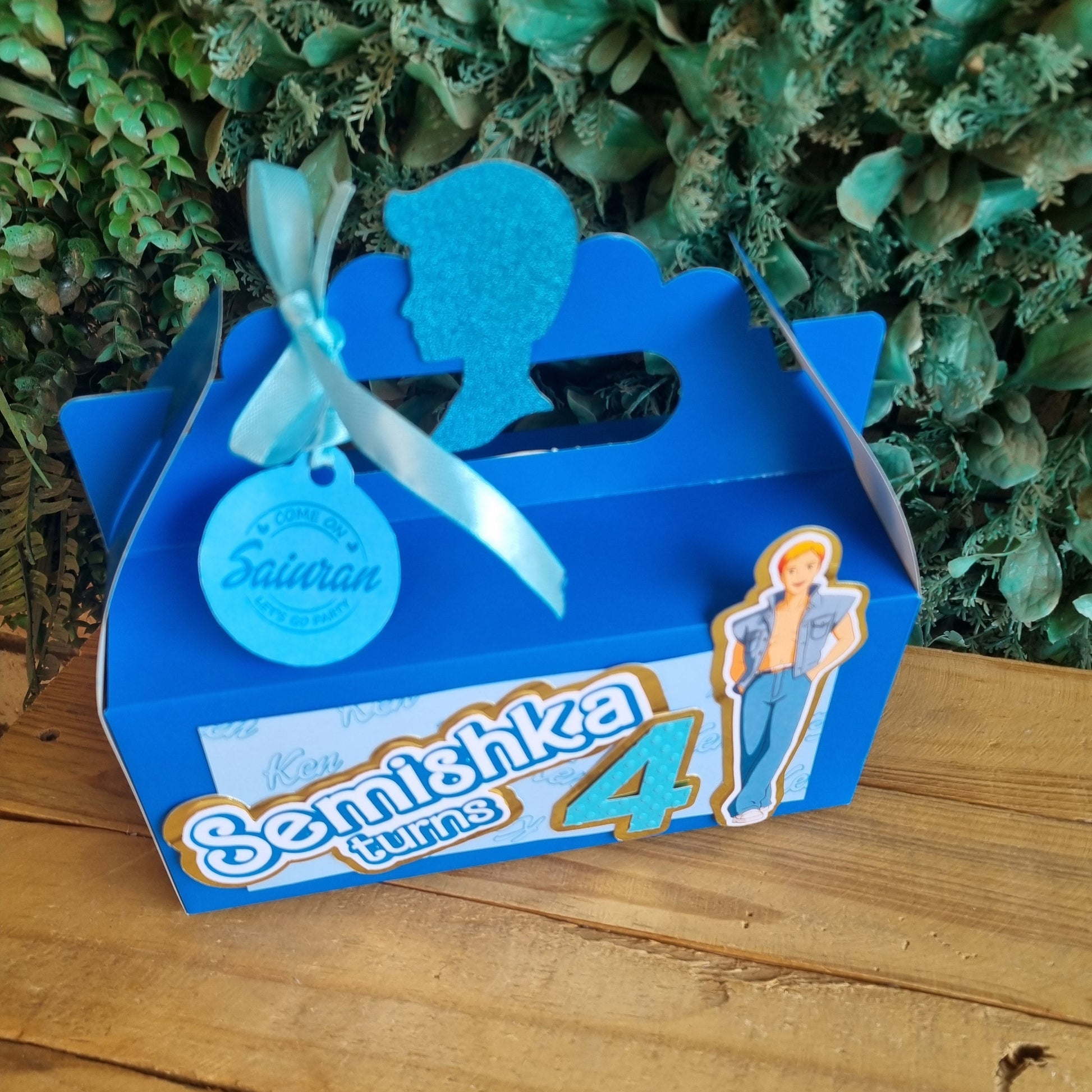 Blue toy figure with packaging on a wooden surface and green foliage background