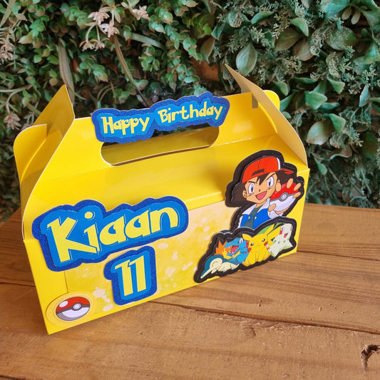 Yellow toy box with cartoon characters on a wooden surface and green plants in the background