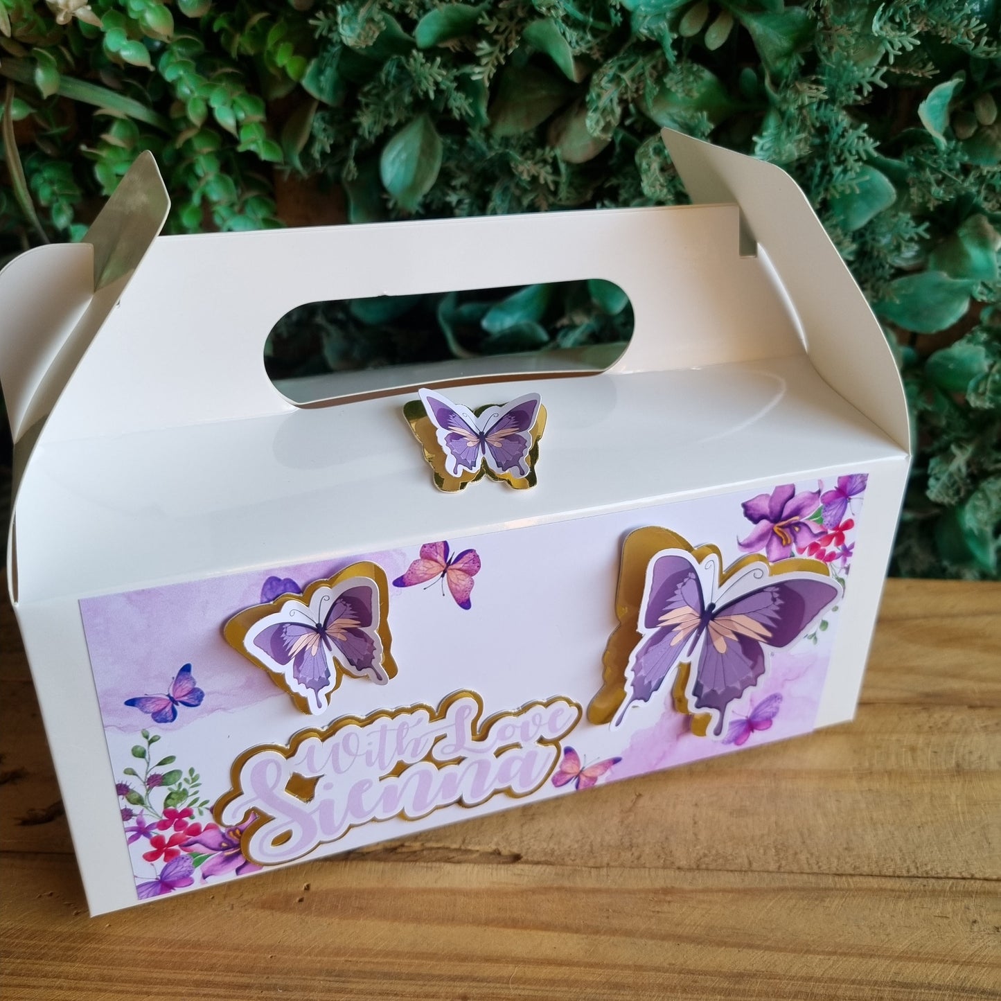 Decorative box with butterfly designs on a wooden surface