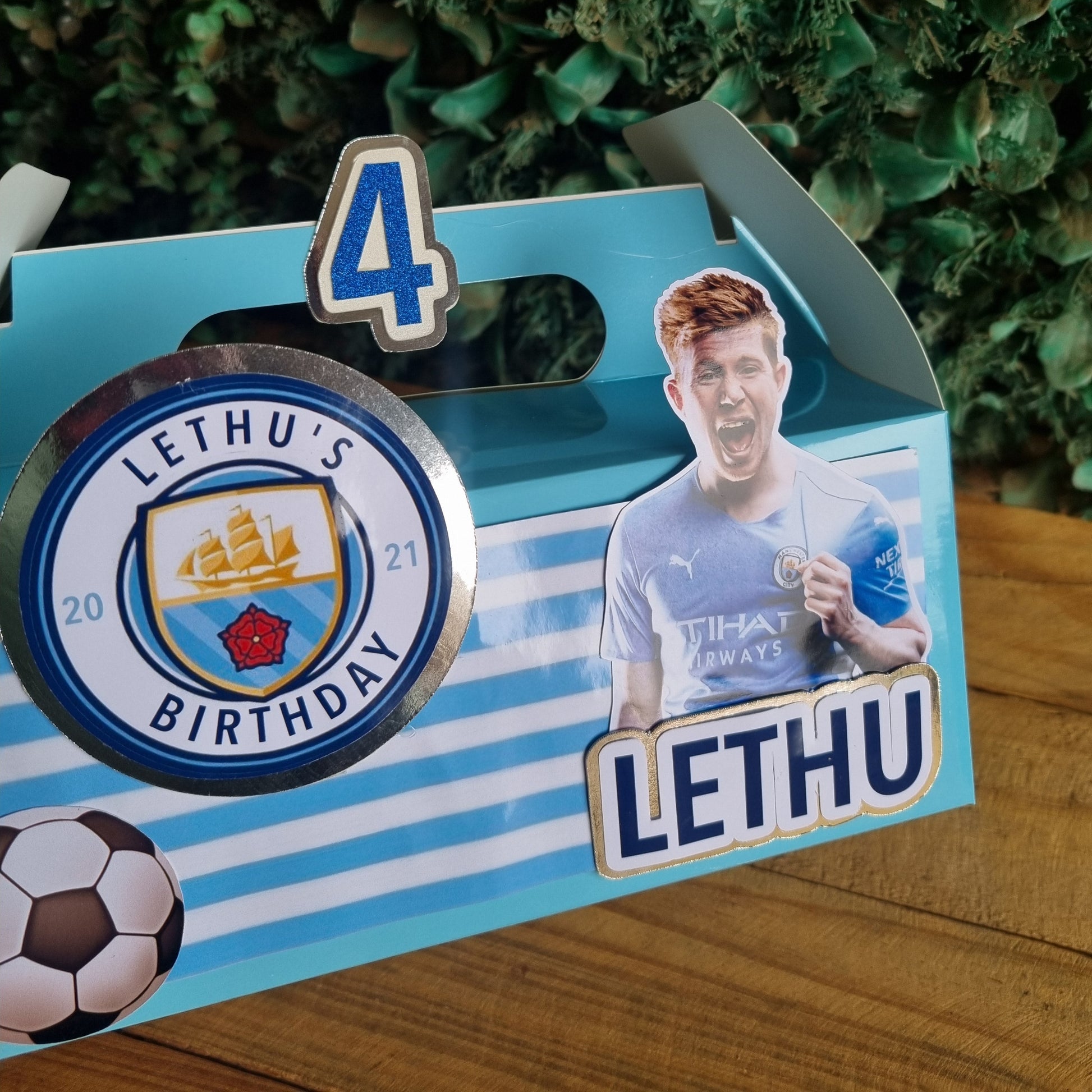 Children's birthday party favor box with Lethu branding and a cutout of a child.