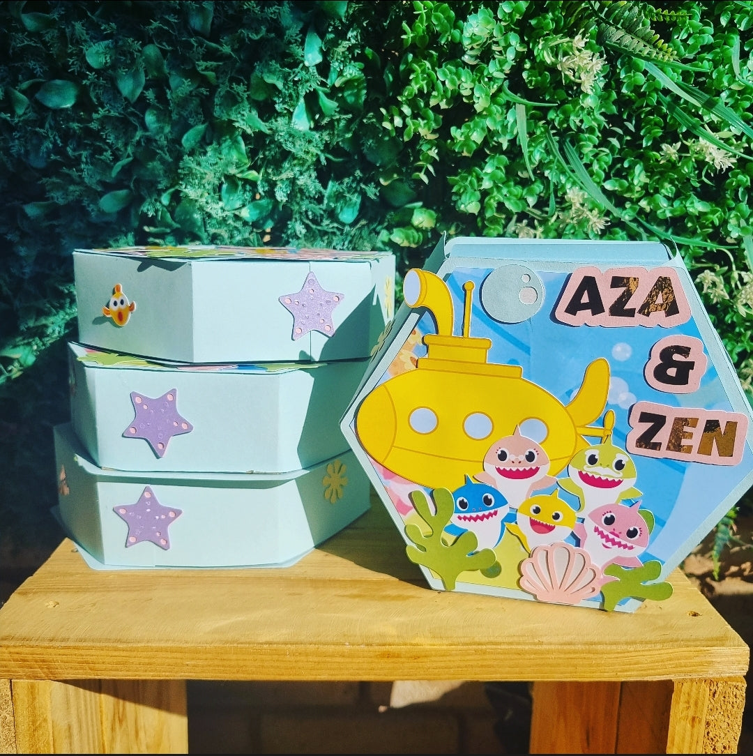 Children's toy set with a yellow submarine and sea creatures on a wooden surface with greenery in the background.
