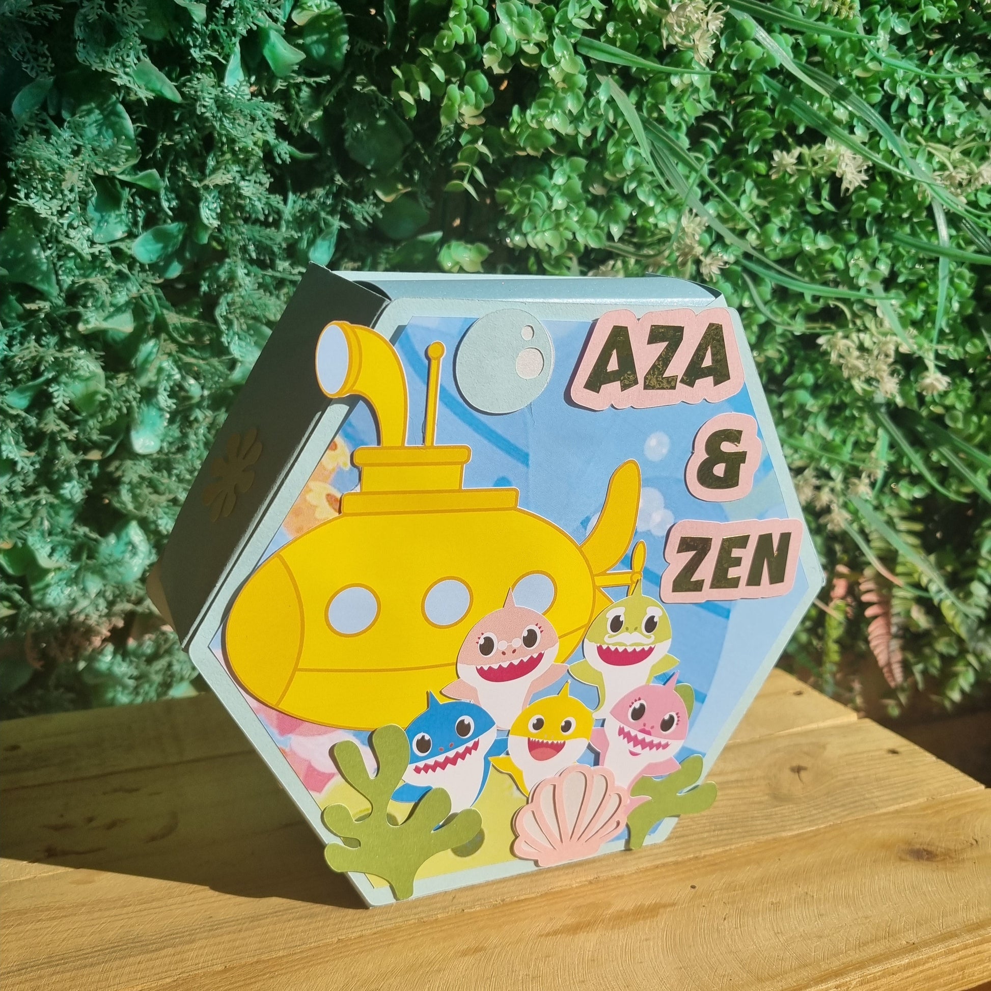 Children's book titled 'Aza & Zen' with a yellow submarine illustration on a wooden surface.
