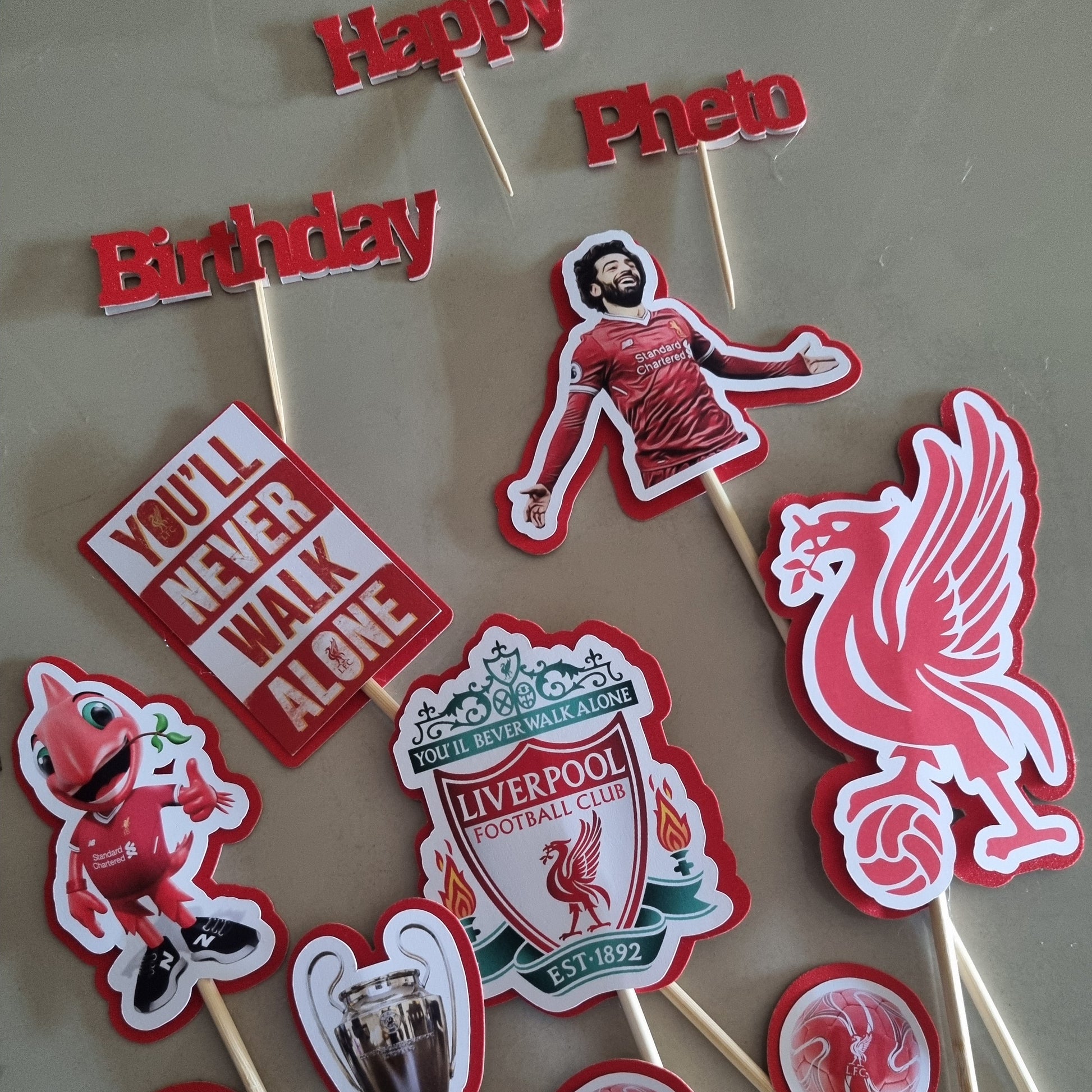 Collection of Liverpool FC-themed cupcake toppers on sticks.