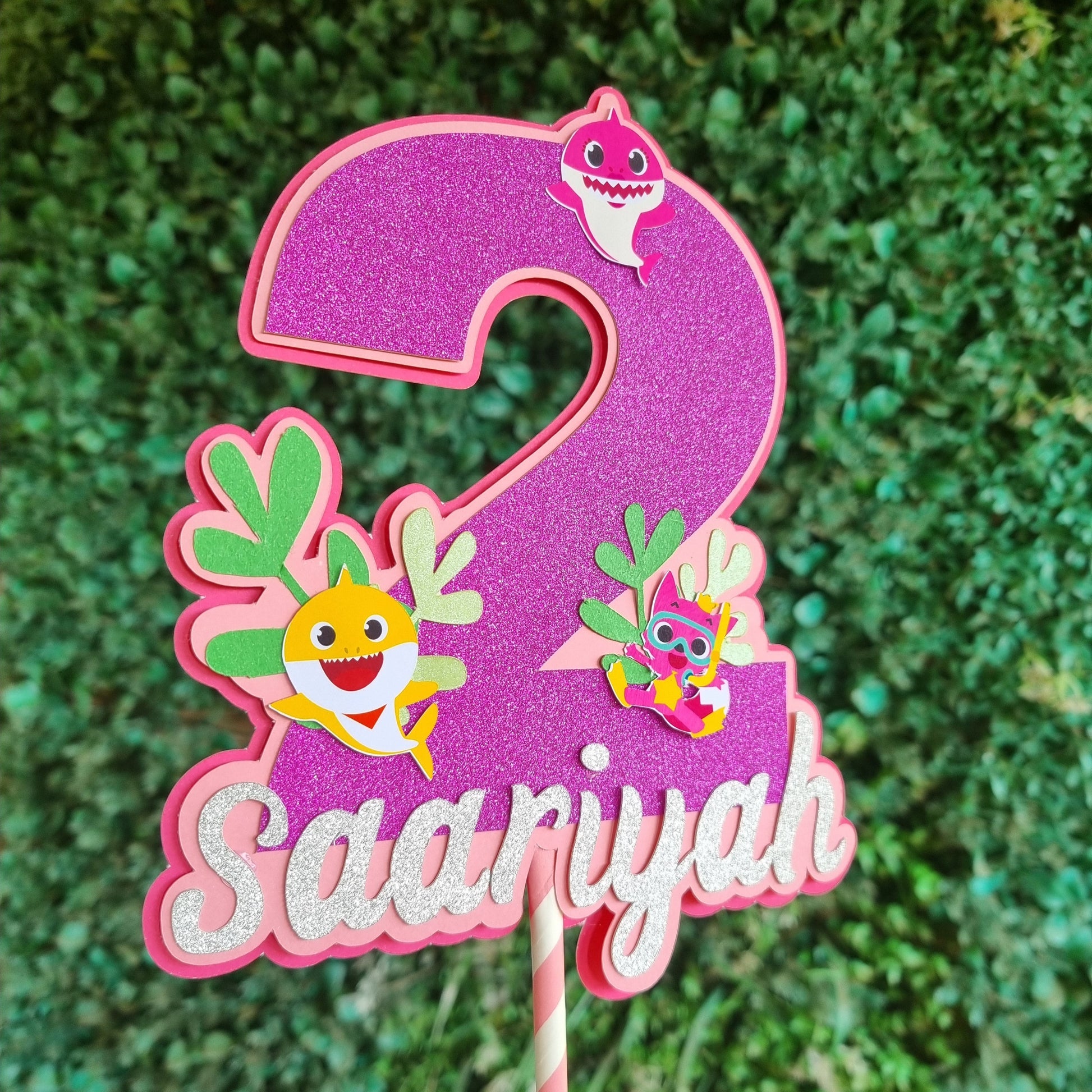 Decorative letter 'S' with colorful designs on a green textured background