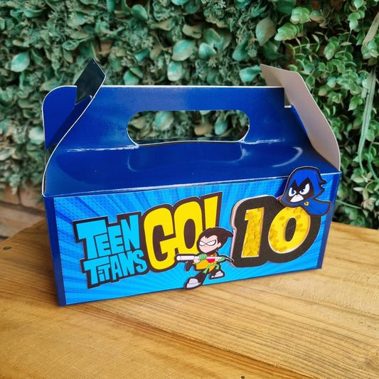 Blue packaging of Teen Titans Go! Titans on a wooden surface with greenery in the background