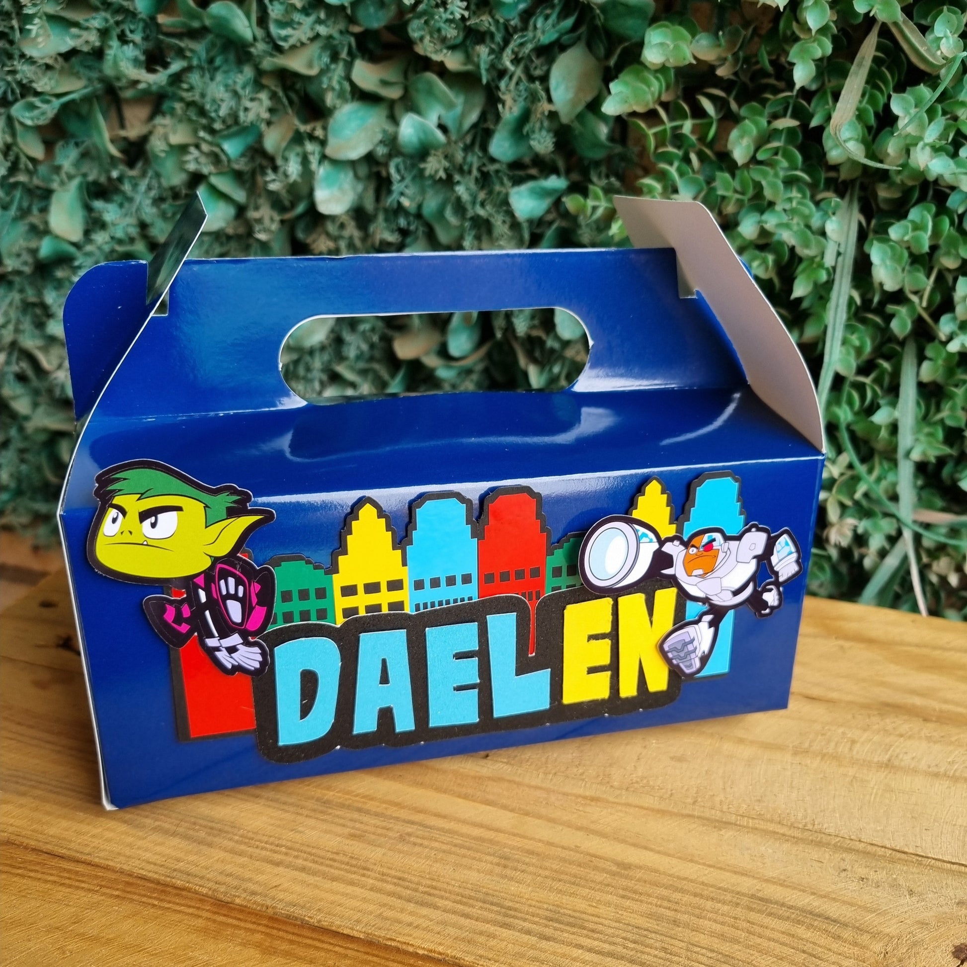 Blue toyDALEK with colorful design on a wooden surface and grass background