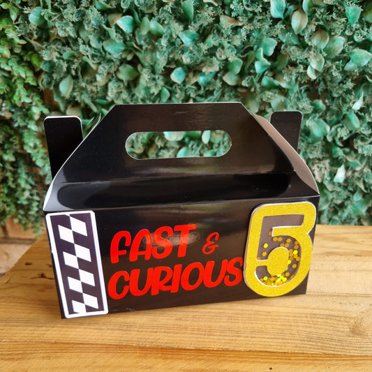 Metallic sign with 'Fast & Curious' text on a textured green and wooden surface