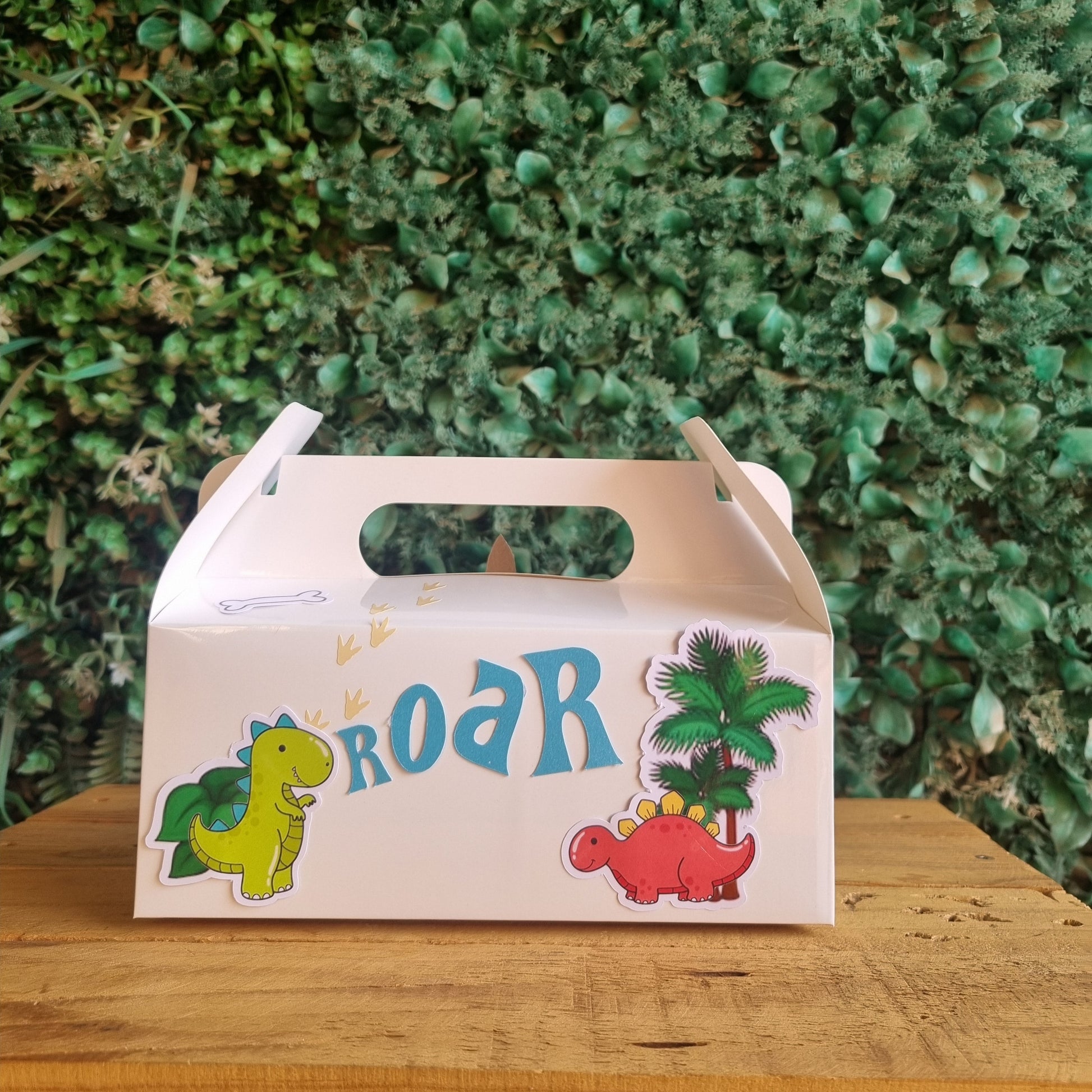 Children's toy box with dinosaur design and 'ROAR' text on a grassy background