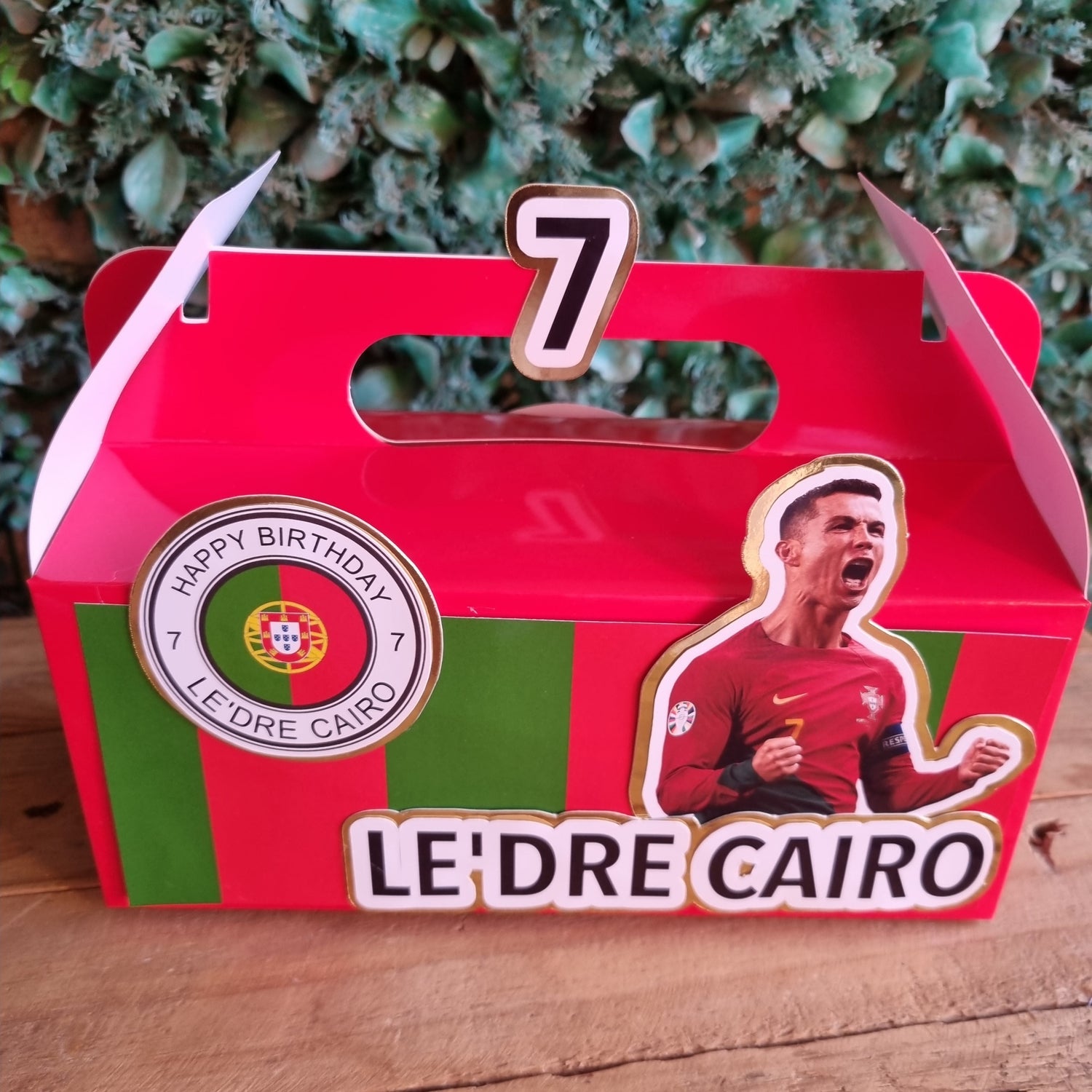 Red card with a player image and 'LE'DRE CAIRO' branding on a wooden surface.