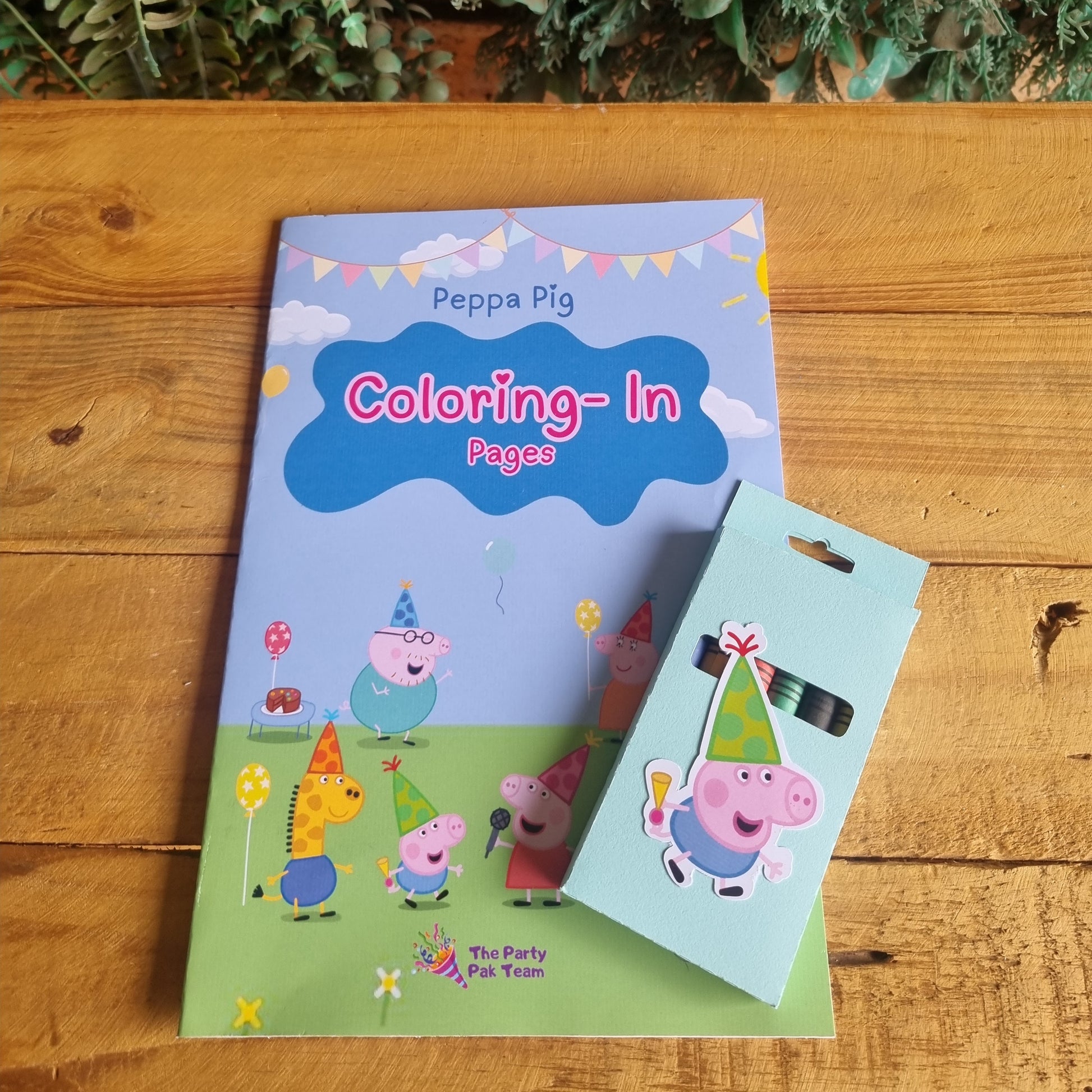 Coloring book and pencil set with Peppa Pig design on a wooden surface