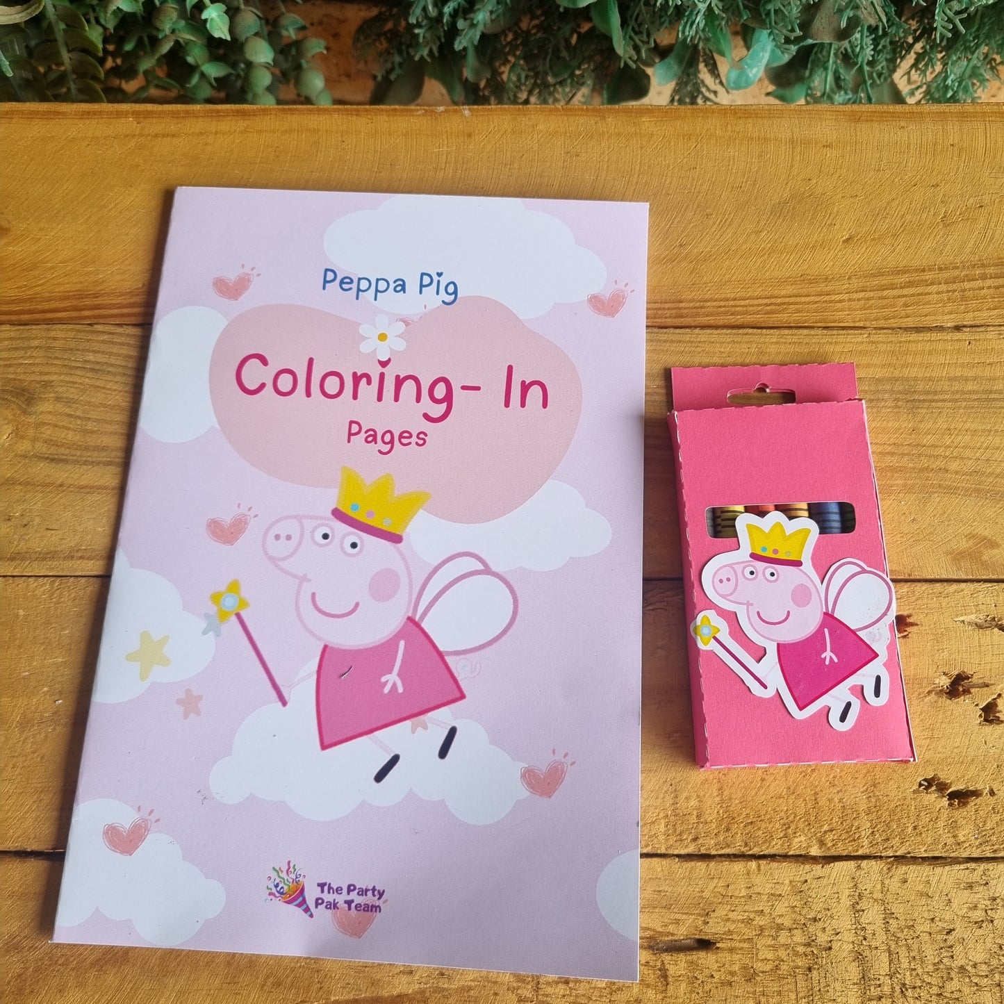 Coloring book with Peppa Pig design on a wooden surface