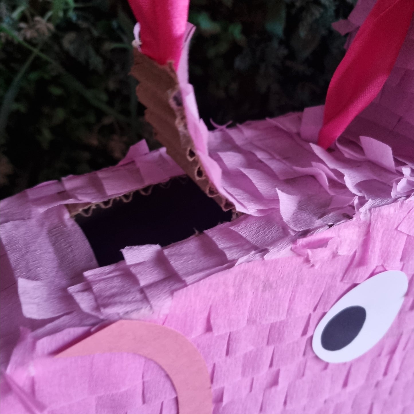 Close-up of a pink piñata with a blurred green background