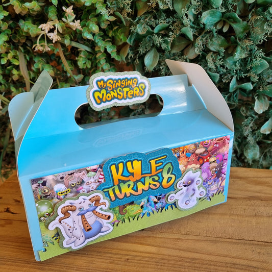 Children's toy box with colorful design on a wooden surface and green plants in the background