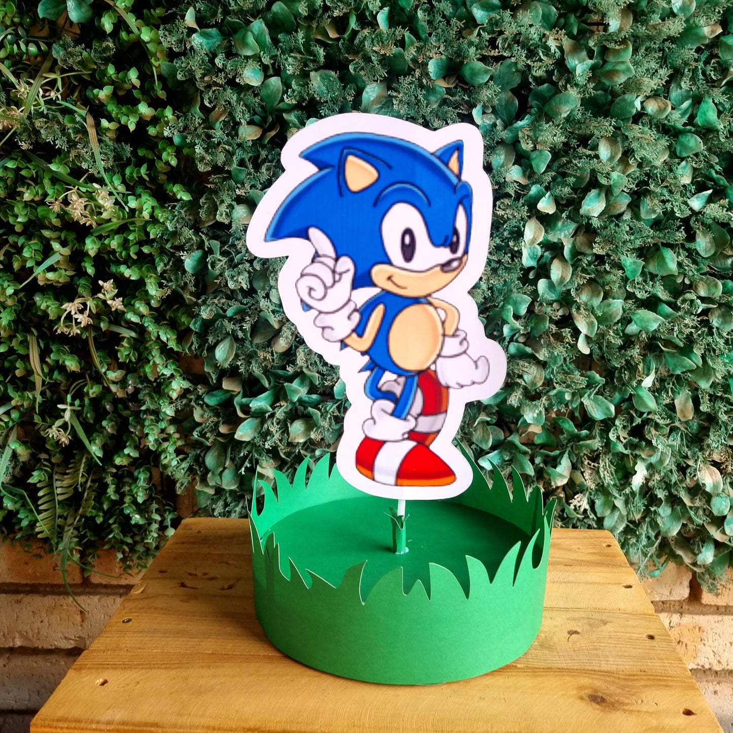 Sonic the Hedgehog character on a green stand against a green foliage background