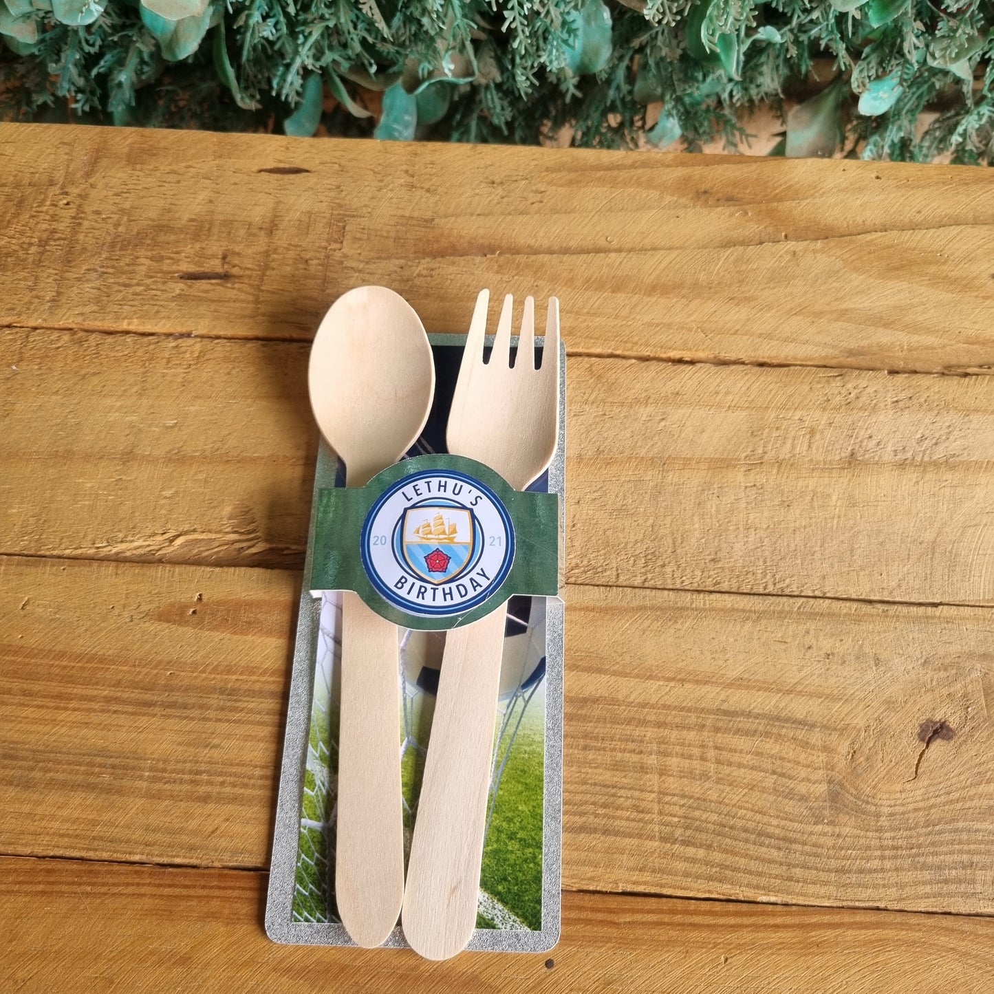 Wooden cutlery set with a branded card on a wooden surface