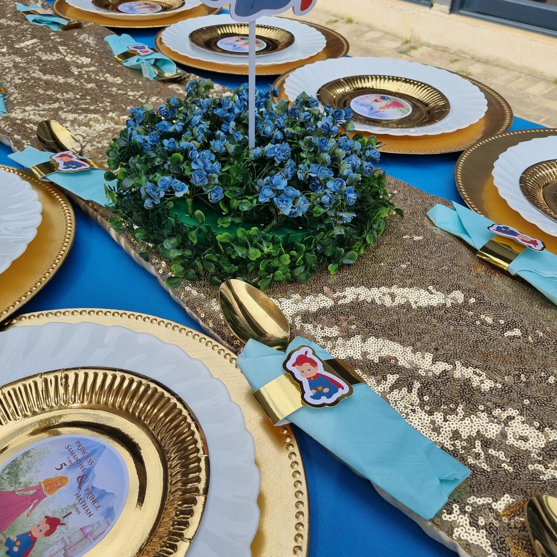 Decorative table setting with gold and blue plates featuring cartoon characters on a blue background.