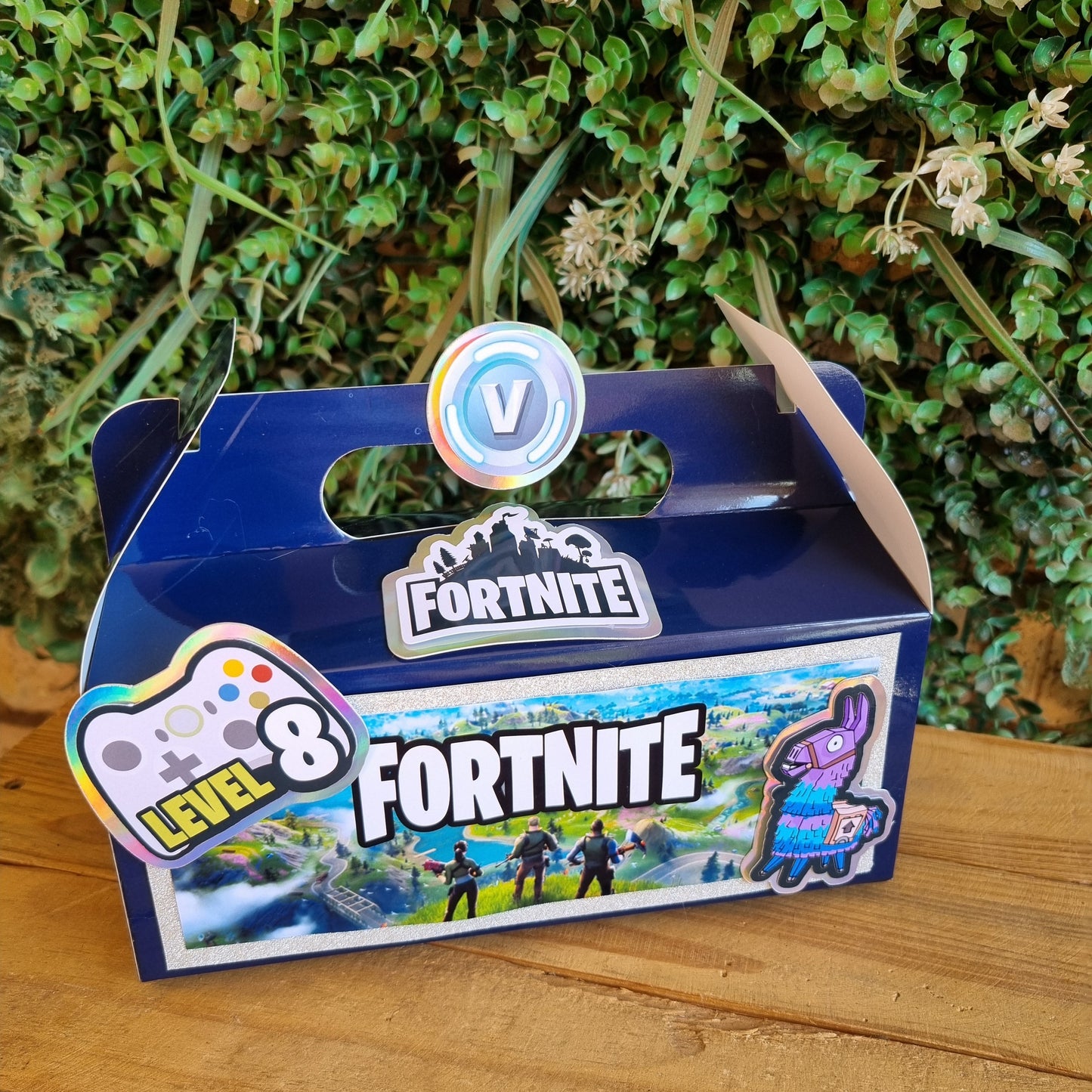Fortnite-themed keychain on a wooden surface with grass in the background