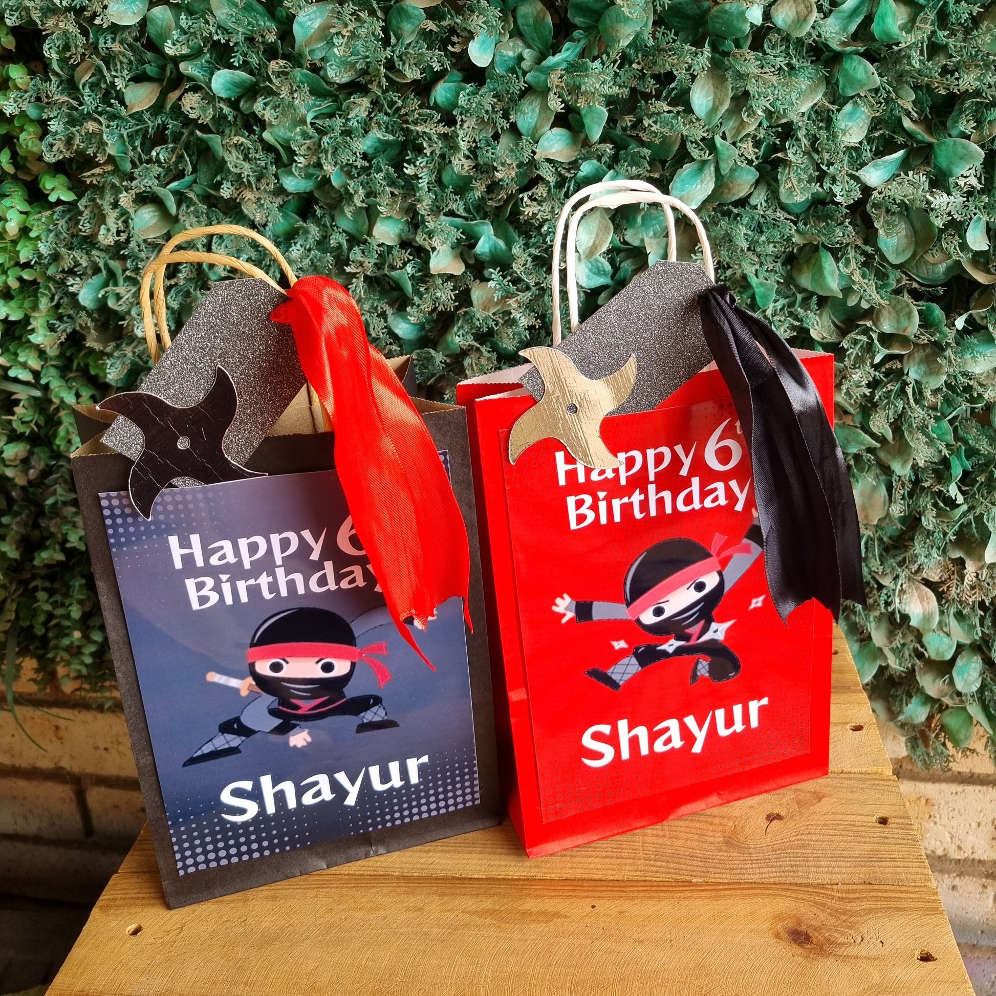 Two 'Happy Birthday Shayur' books with pirate-themed covers on a wooden surface.