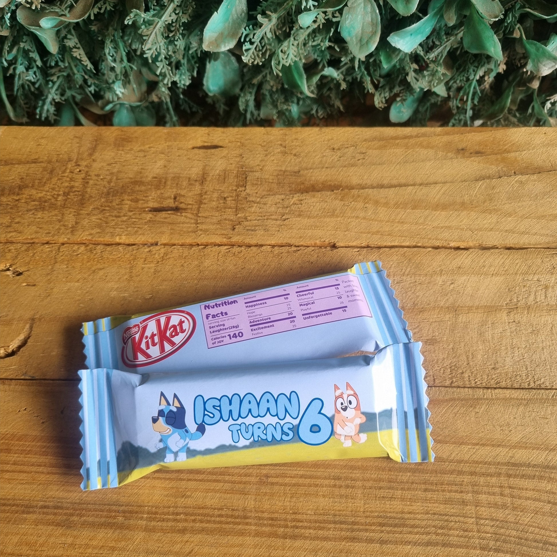 KitKat chocolate bar with a cartoon character on a wooden surface