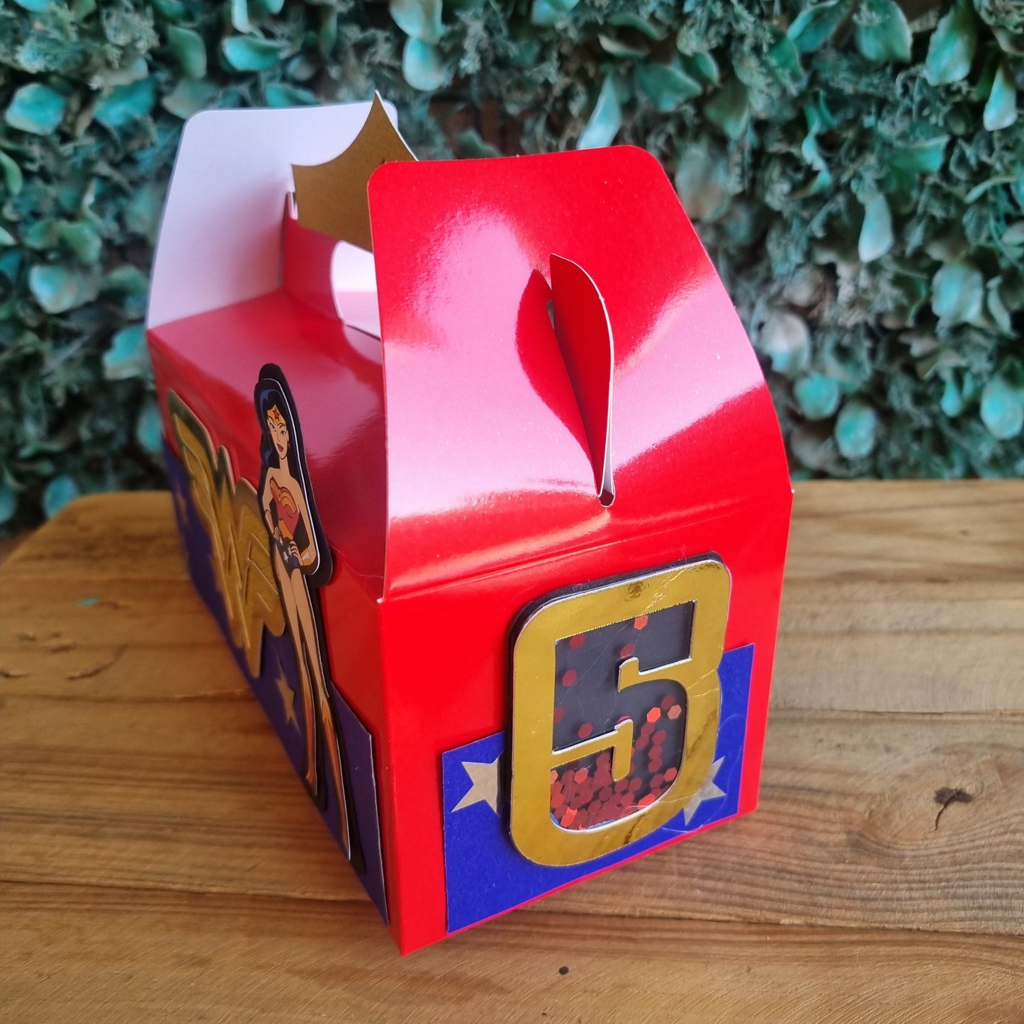Red toy box with a character on a wooden surface