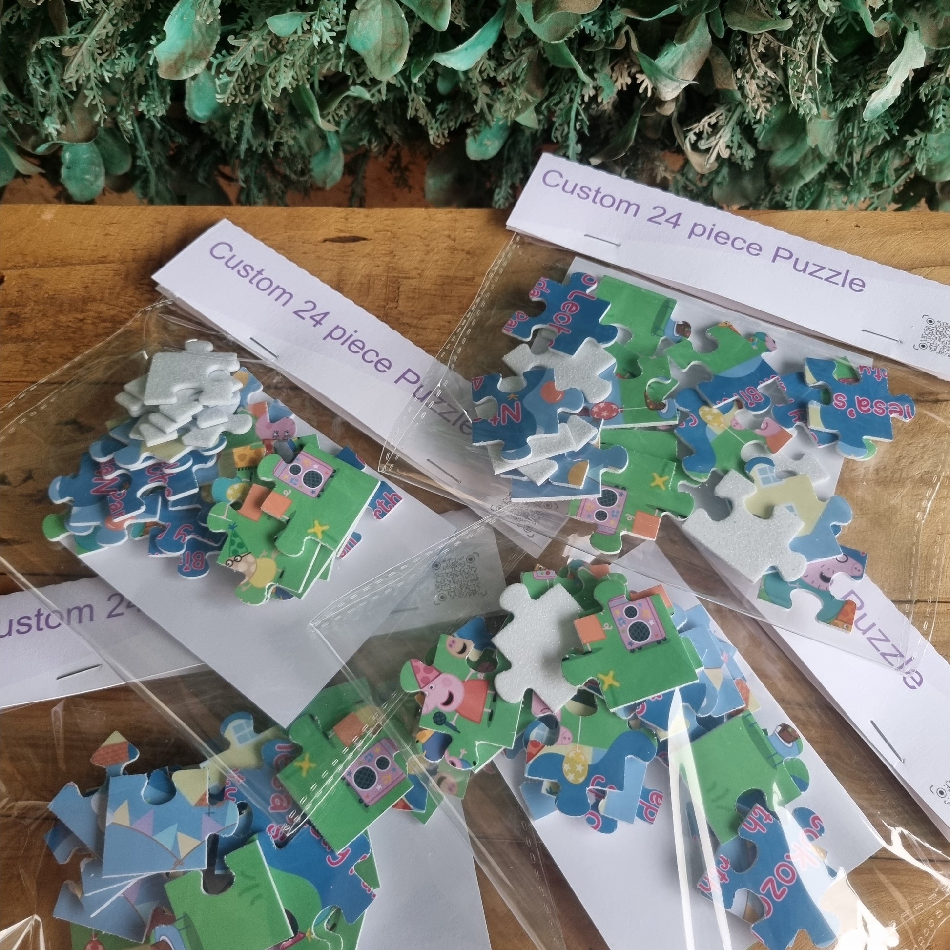 Jigsaw puzzle pieces on a wooden surface with packaging and greenery.