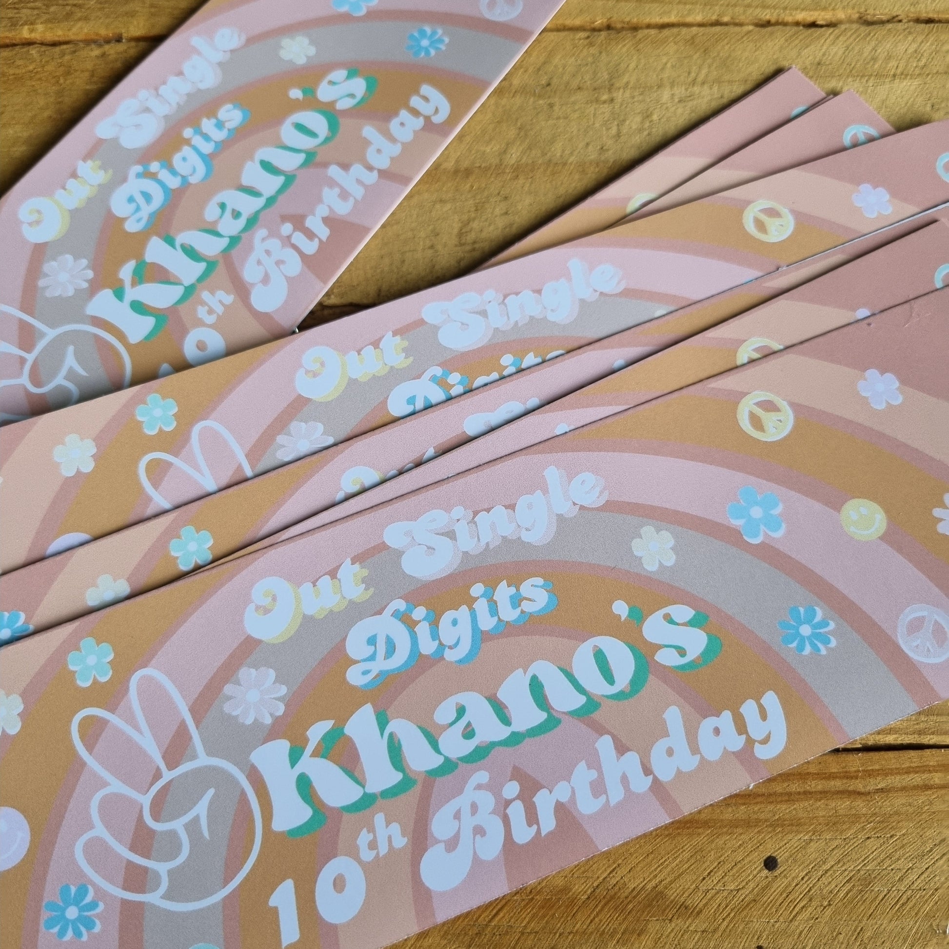 Decorative birthday banners with floral designs on a wooden surface