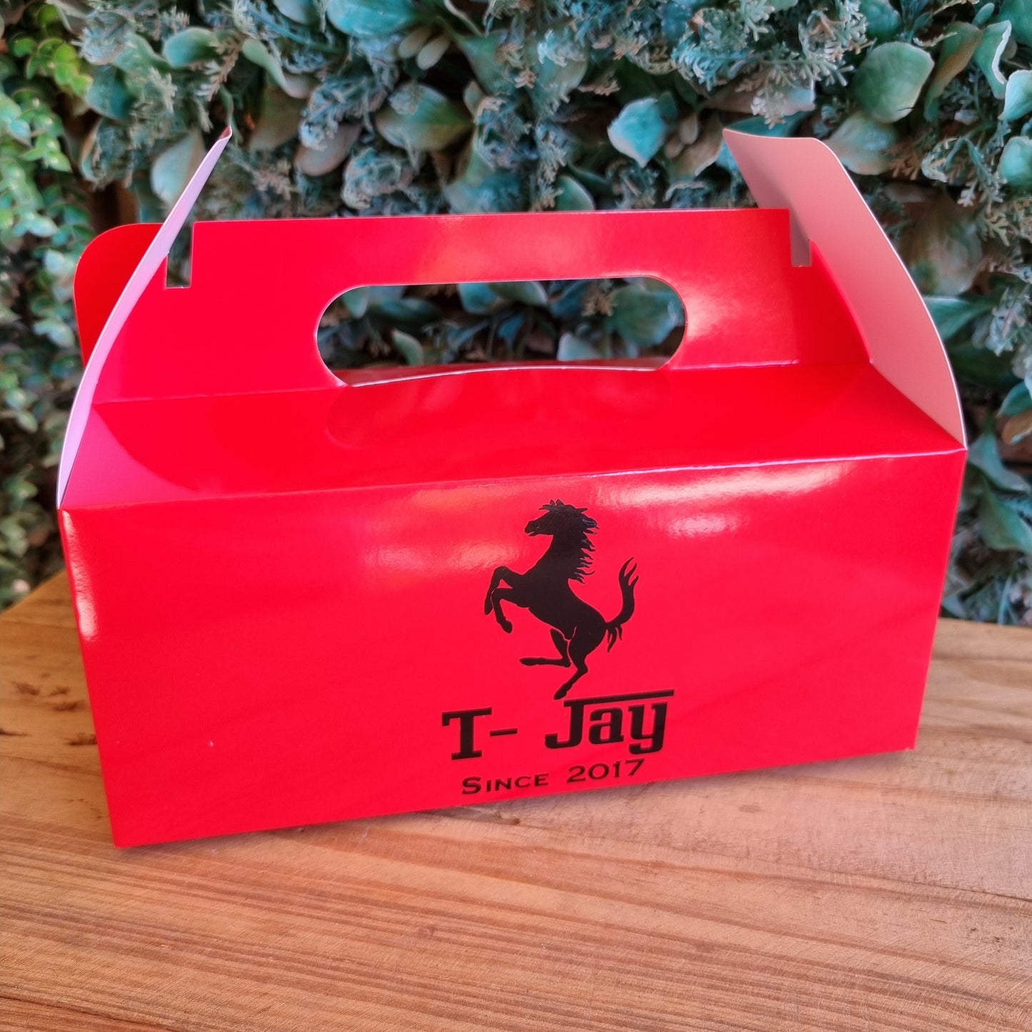 Red box with a horse logo on a wooden surface