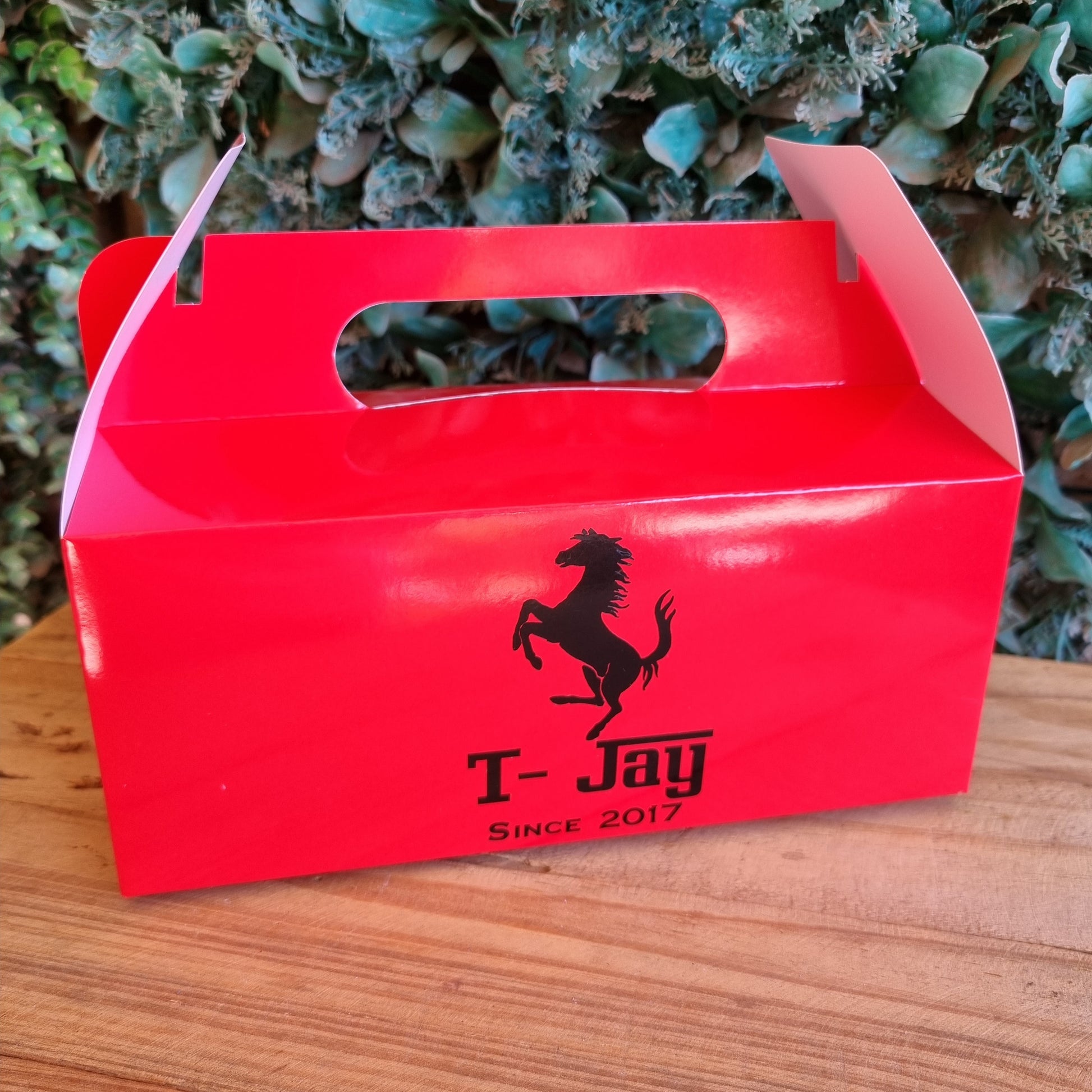 Red box with a horse logo on a wooden surface