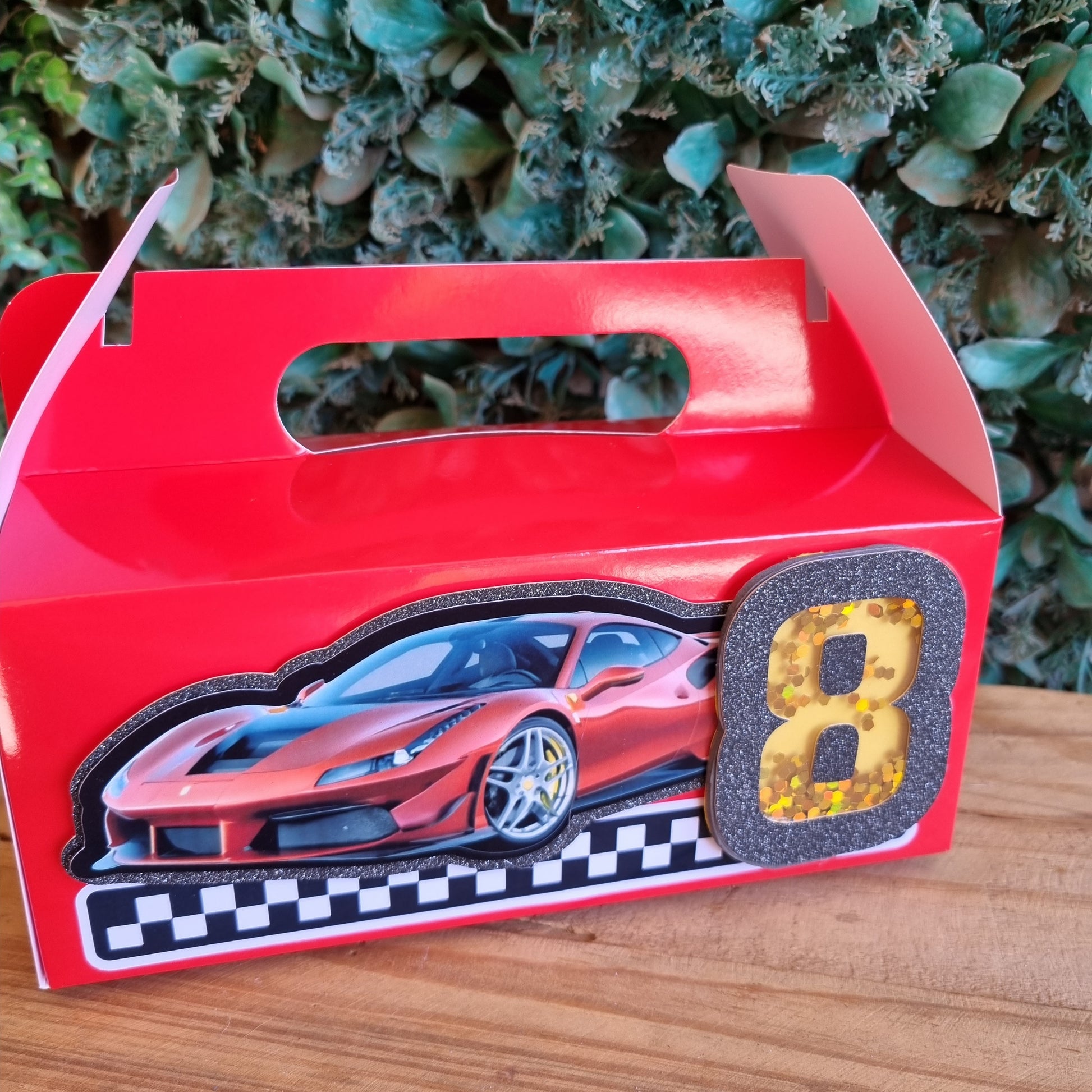 Red toy car with a checkered pattern on a wooden surface