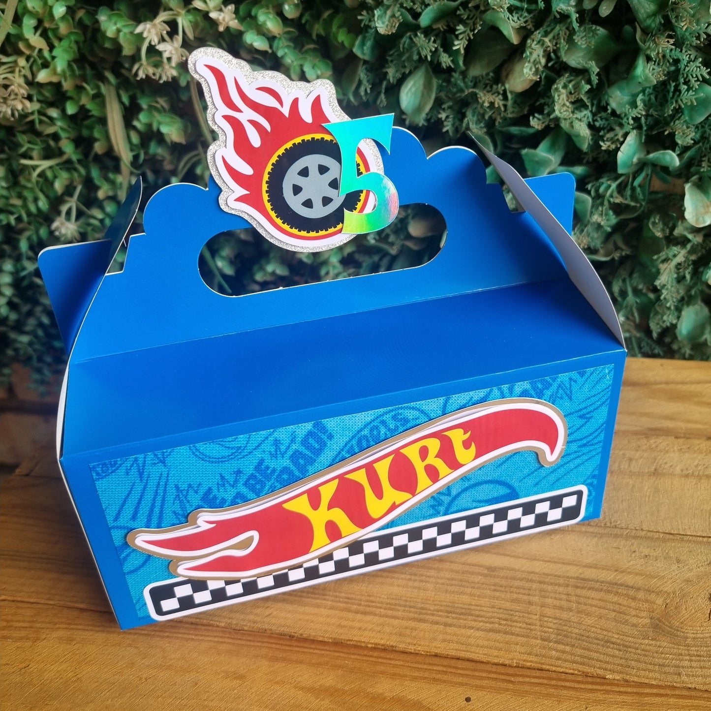 Blue toy car box with 'Hot Wheels' branding on a wooden surface.