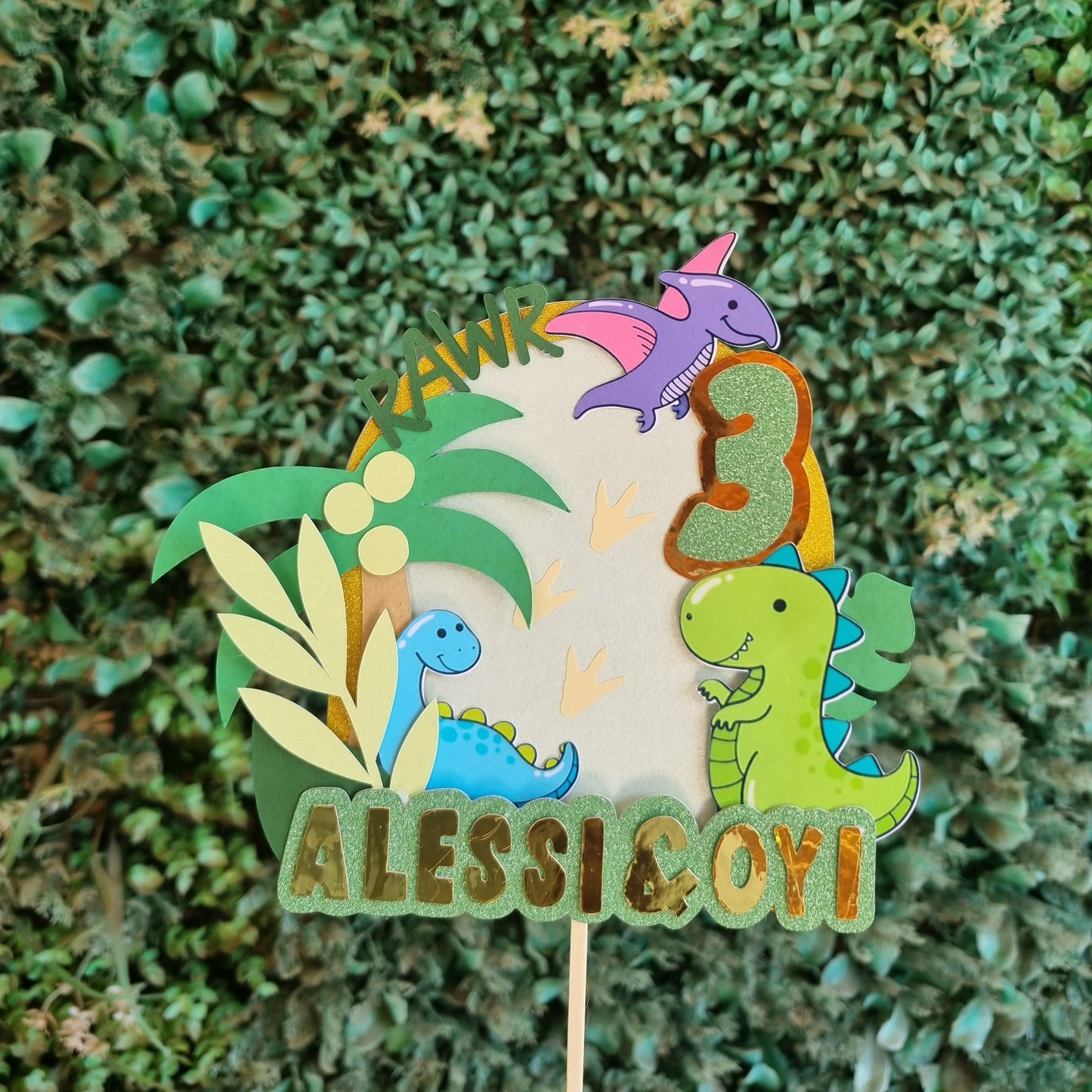 Colorful dinosaur-shaped brooch on a green leafy background
