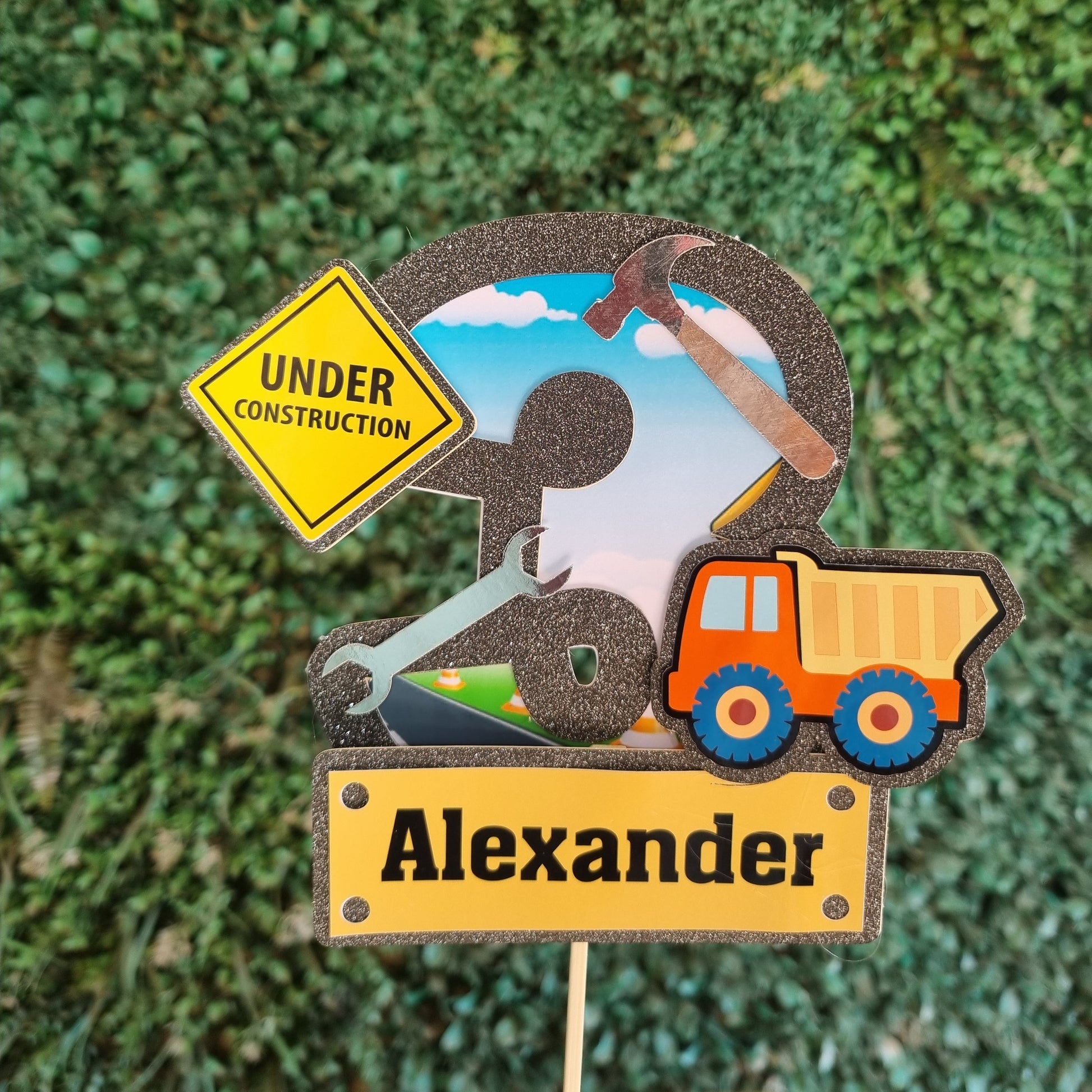 Colorful wooden nameplate with tools and 'Under Construction' sign on a green textured background