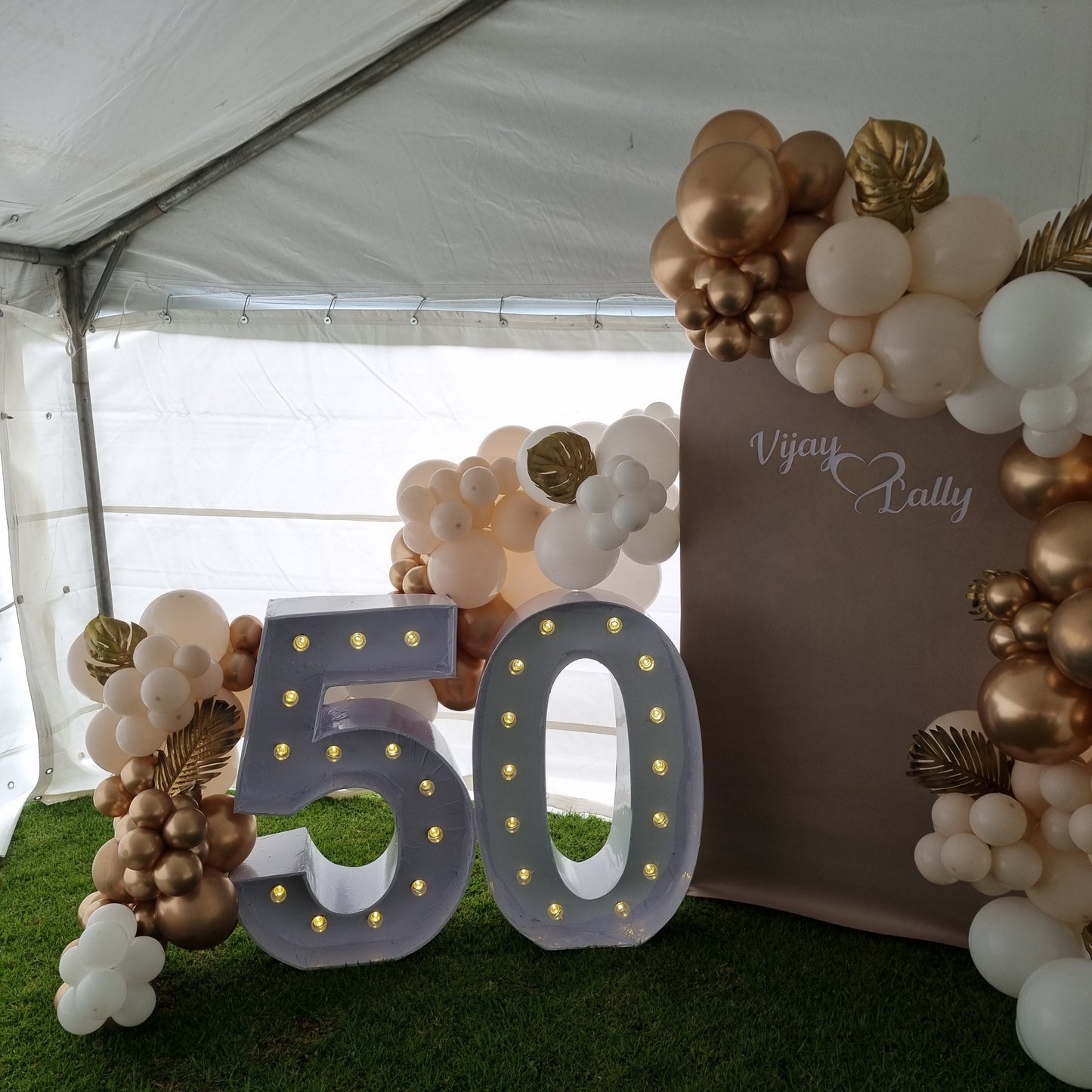 Decorative setup with balloons and '50' sign at a celebration event.