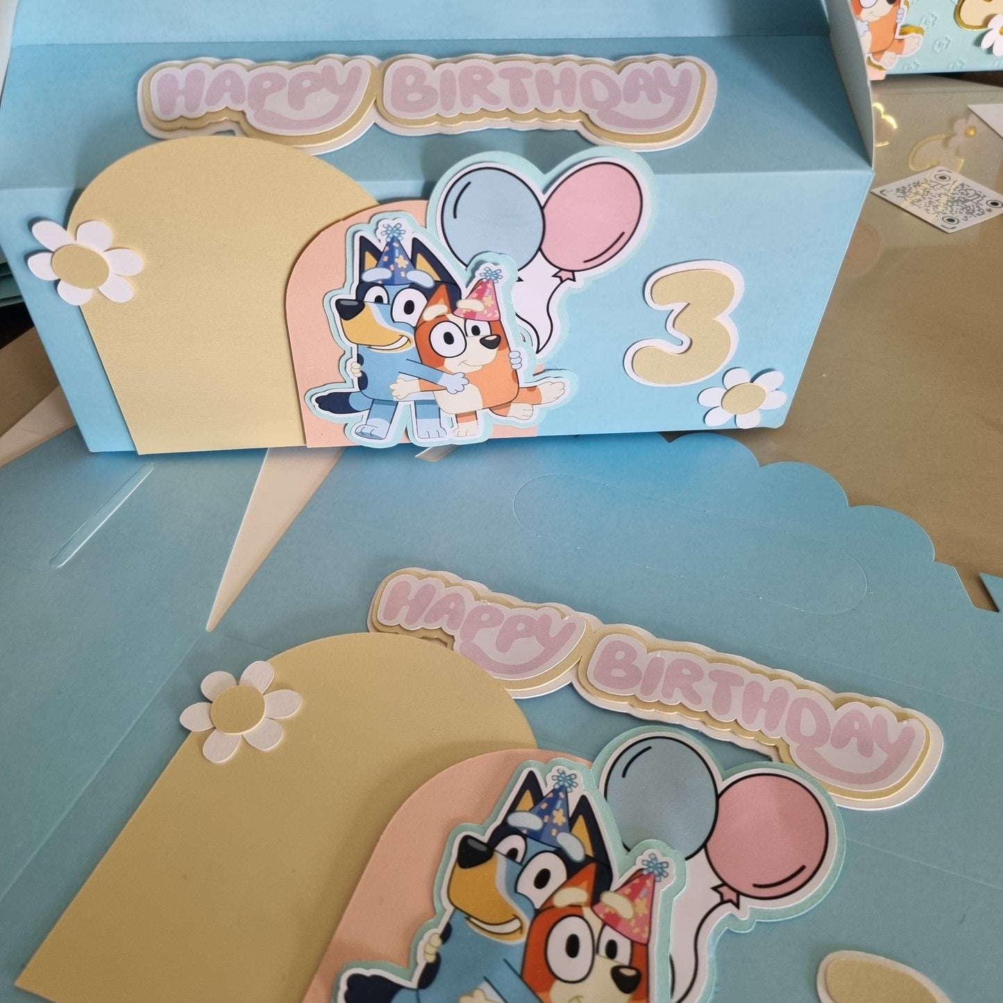 Children's birthday card with cartoon characters and 'Happy Birthday' text on a blue background.