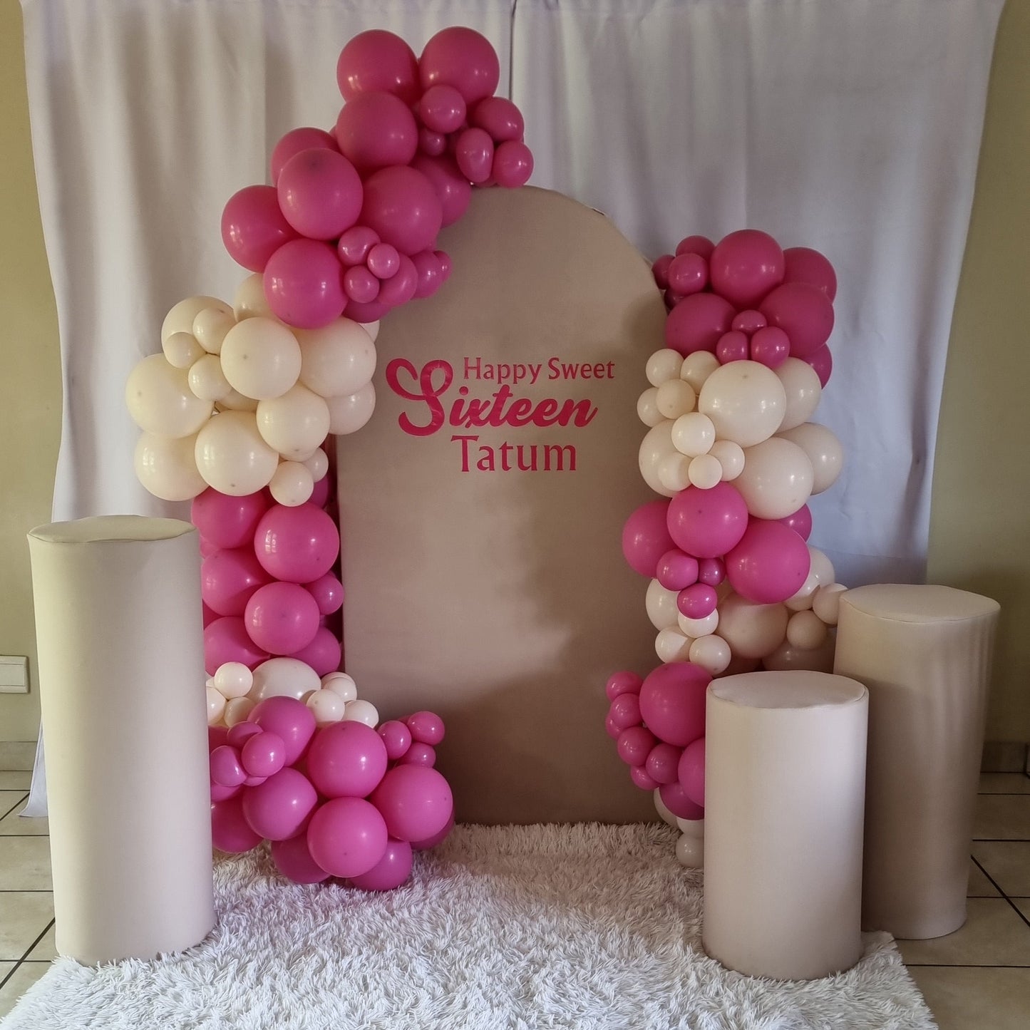 Decorative setup with balloons and a chair on a tiled floor.